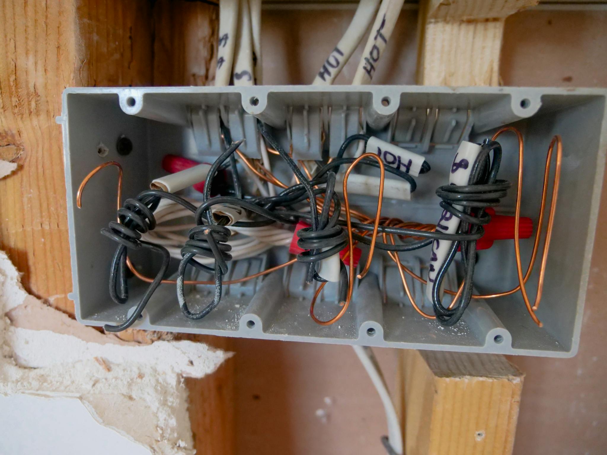 Detailed view of an open electrical switchboard with tangled wires and cables.